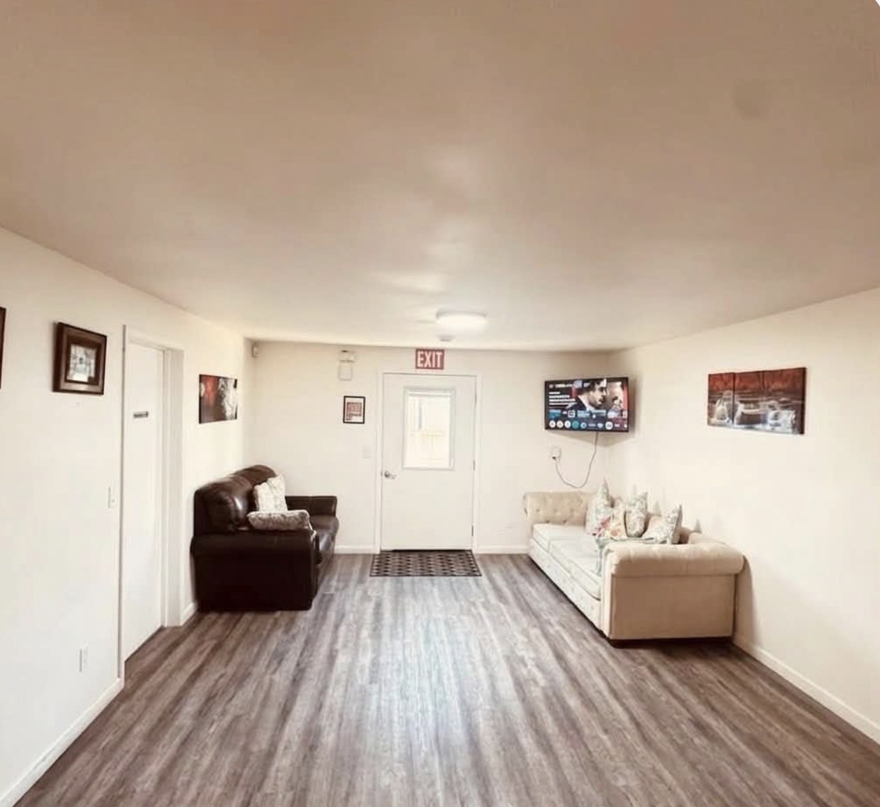 Spacious common living area with sofas and TV